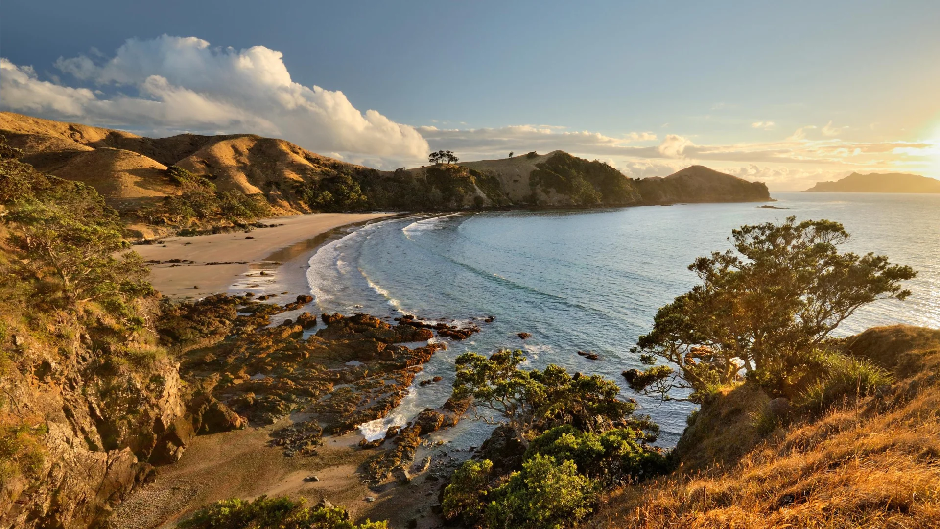 Uitzicht op een baai op Great Barrier Island met ondergaande zon