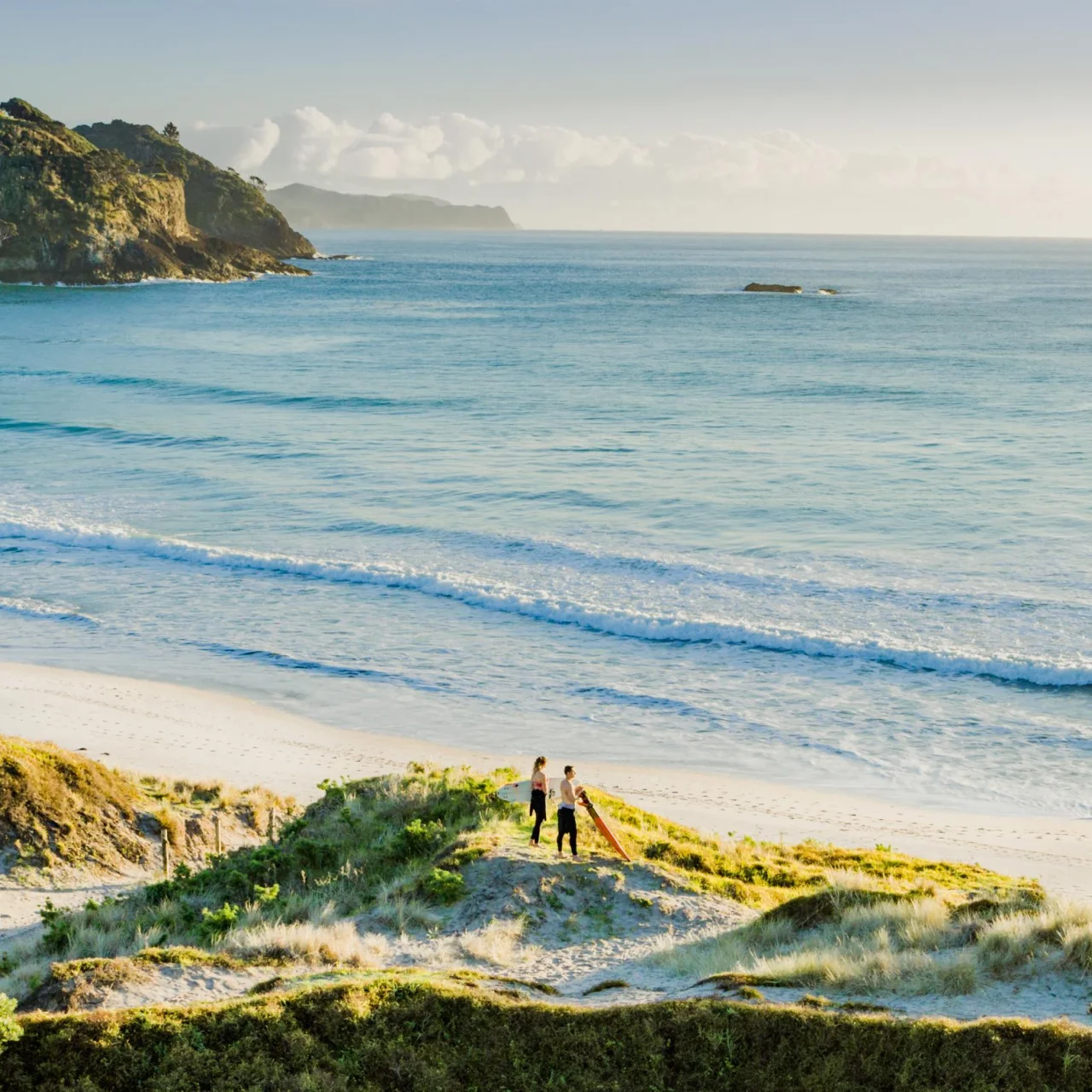 Twee surfers in de duinen bij Medlands Beach, Great Barrier Island