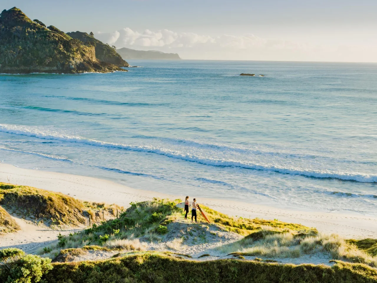 Twee surfers in de duinen bij Medlands Beach, Great Barrier Island