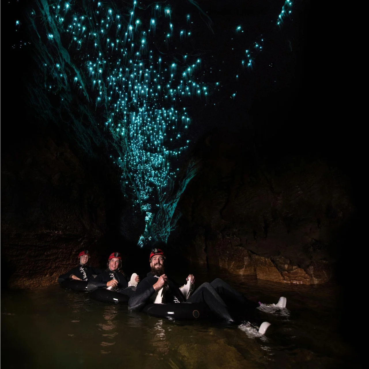 Liggend in het water, in een band, kijken naar de glimwormen in de grotten van Waitomo