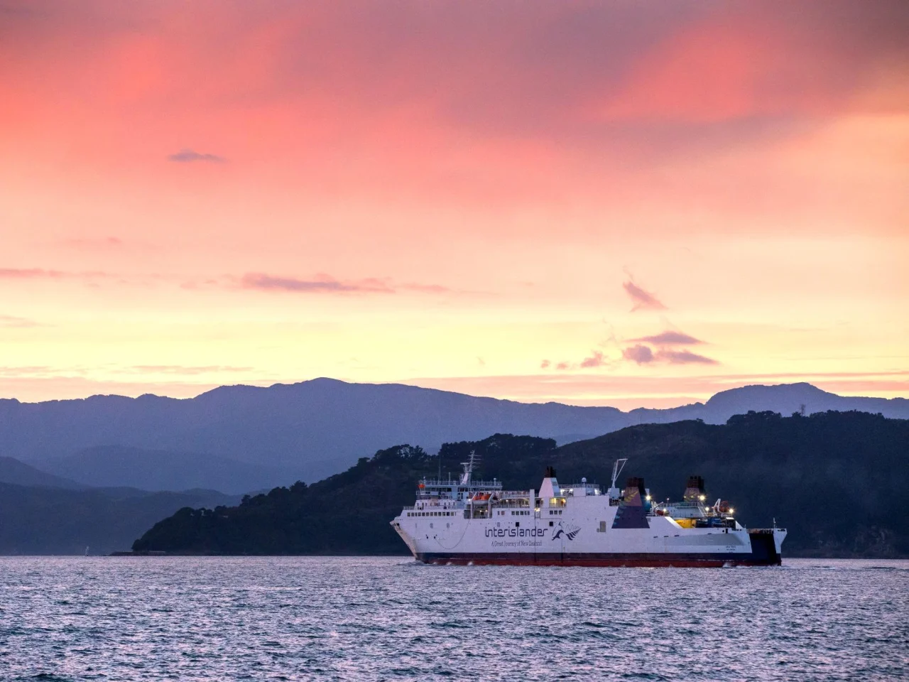 De Interislander ferry vaart tussen Wellington en Picton bij zonsopkomst