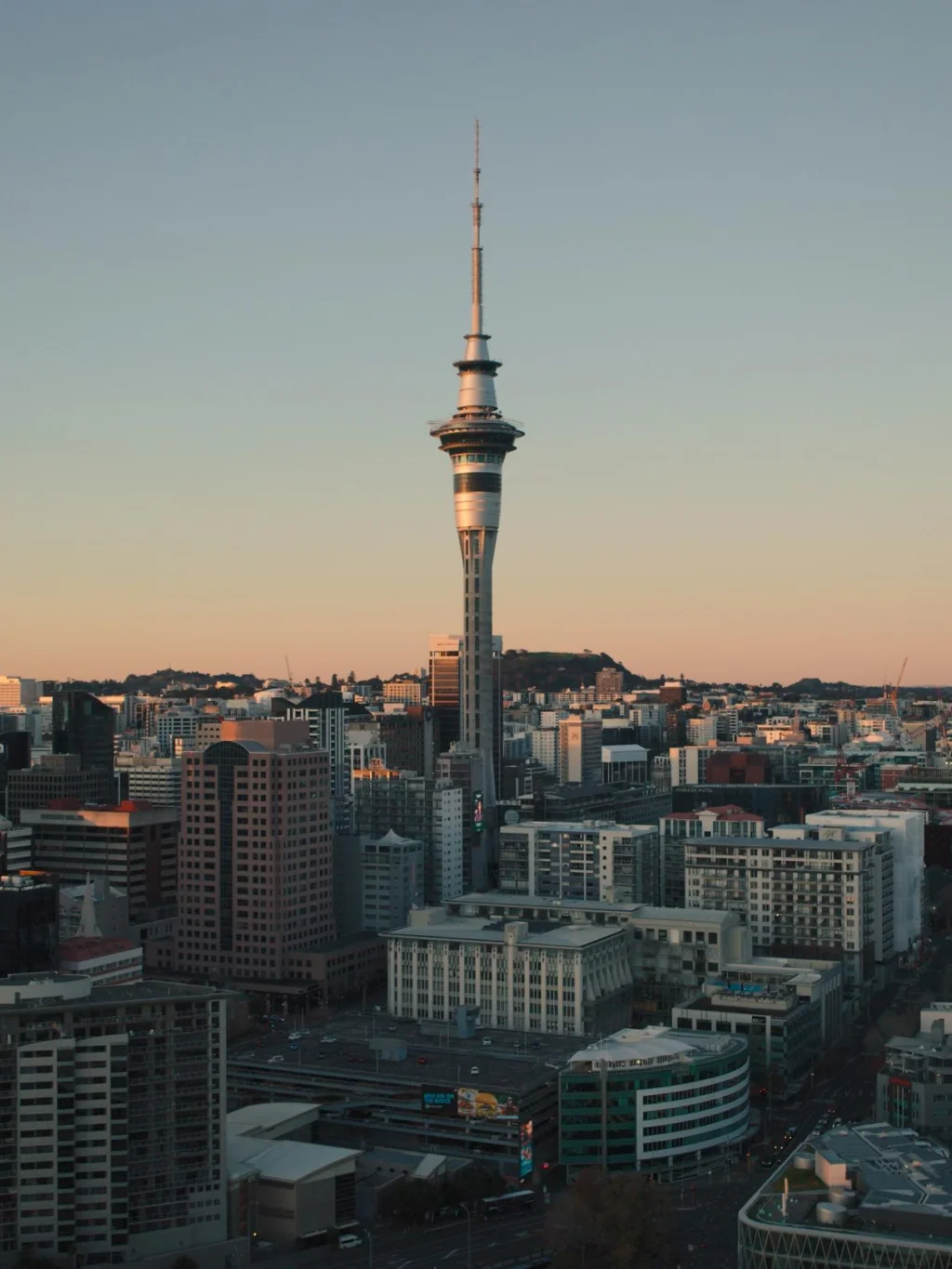 Skyline van Auckland met de Skytower tijdens zonsopkomst