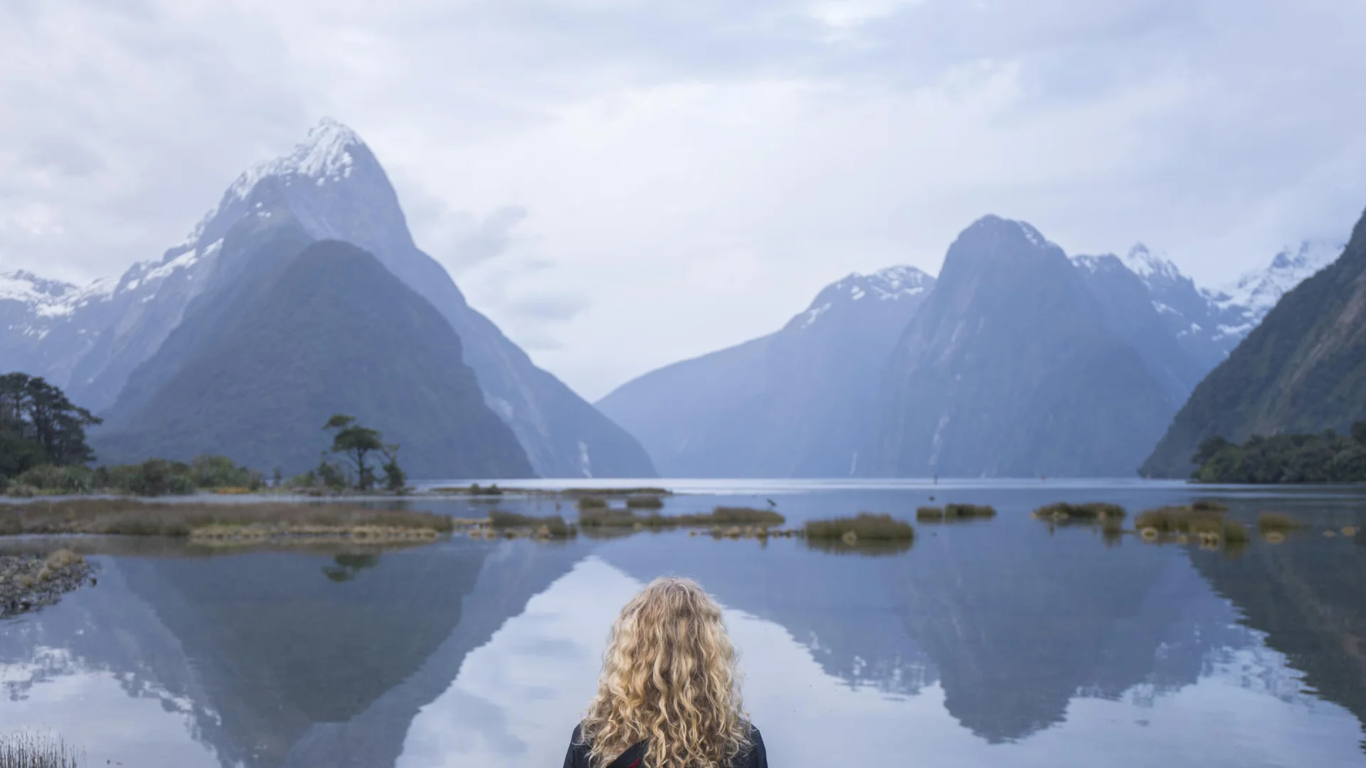 Vrouw kijkend naar Mitre Peak in de fjorden van Milford Sound