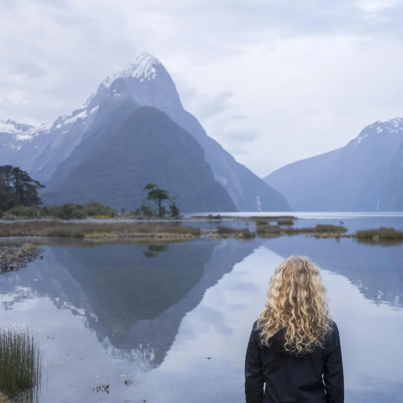 Vrouw kijkend naar Mitre Peak in de fjorden van Milford Sound