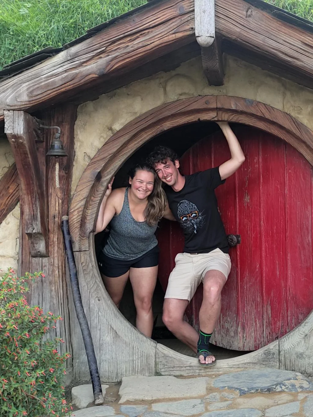 Judith en Bernard van opDroomreis.nu staat in de deuropening van een hobbit-huisje op de filmset van Hobbiton en Lord of the Rings in Matamata, Nieuw-Zeeland