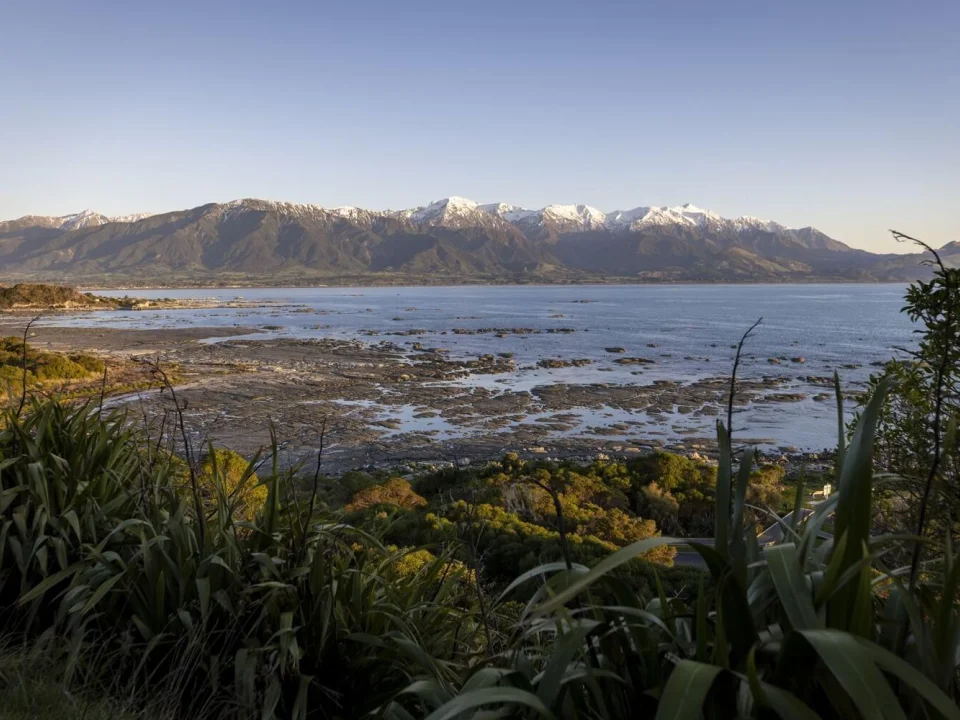 Besneeuwde bergtoppen bij Kaikoura met de zee